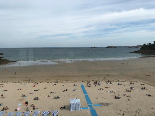 a group of people on a beach near the water at Vue mer exceptionnelle in Dinard
