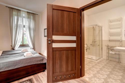 sypialnia z drzwiami prowadzącymi do łazienki w obiekcie Hotel Charlotta w Jedlinie-Zdroju