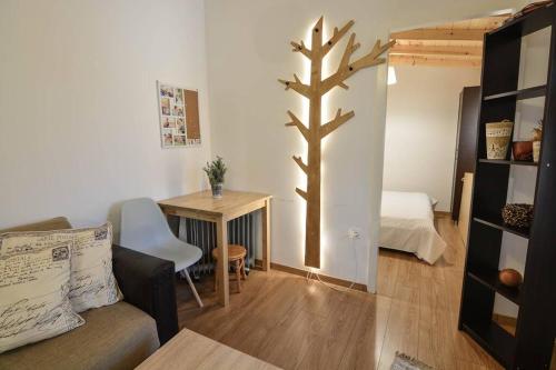 - un salon avec une table et un arbre sur le mur dans l'établissement Dream Apartment Xylokastro, à Xylokastro