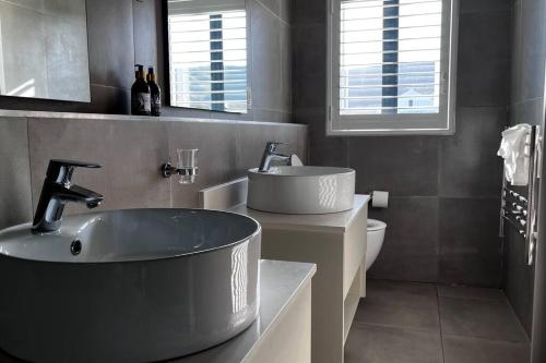 a bathroom with a large tub and a sink at Hermanus Waterfront Apartment No.20 in Hermanus