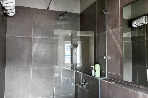 a bathroom with a shower with a glass wall at Hermanus Waterfront Apartment No.20 in Hermanus