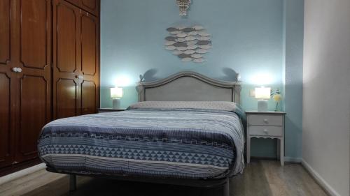 1 dormitorio con 1 cama y 2 luces en la pared en Casa Marenga El Palo, en Málaga