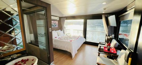 a room with a bed and a balcony on a boat at UniCharm Cruise in Ha Long