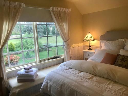 um quarto com uma cama e uma grande janela em Hawk's Nest Bed & Breakfast em Bathurst