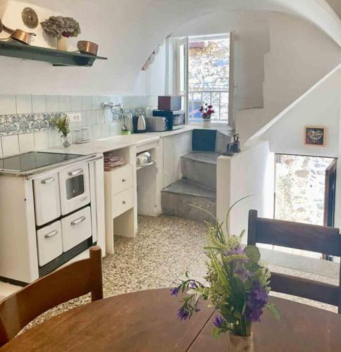 a kitchen with a table and a staircase in a room at Casa Celestine in Via Orsini Isolabona Liguria Italy Sleeps 5 in Isolabona