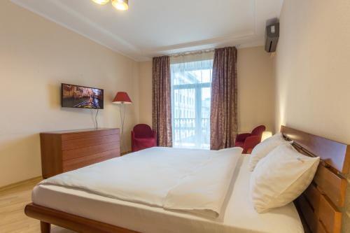 a bedroom with a large bed and a window at Cheap Apartments in Kyiv