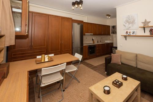 een woonkamer met een bank en een tafel en een keuken bij Dream Apartment Karpenisi in Karpenisi