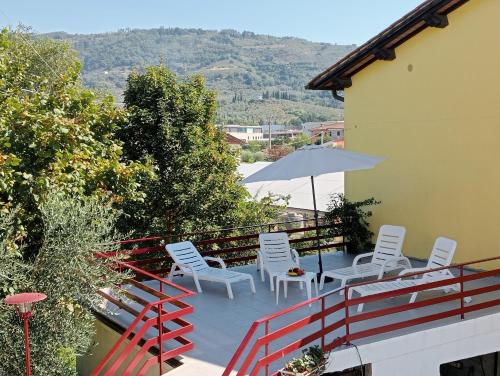 un patio con sillas blancas y una sombrilla en casa Guanita, en Santa Lucía