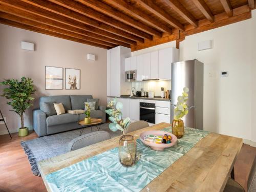 a kitchen and living room with a table and a couch at Limehome Granada Calle Mirasol in Granada