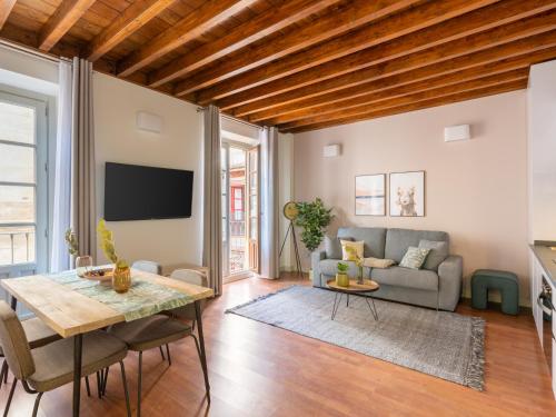 a living room with a table and a couch at Limehome Granada Calle Mirasol in Granada