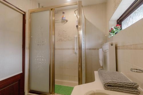 a bathroom with a shower with a toilet and a sink at Palm Bay's Luxury Bungalow - Self Check In & Parking in Margate