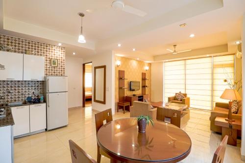 cocina y sala de estar con mesa en una habitación en Ahuja Residency Noida, en Noida