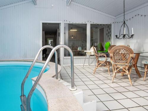 a house with a swimming pool and a table and chairs at 8 person holiday home in rsted in Kare