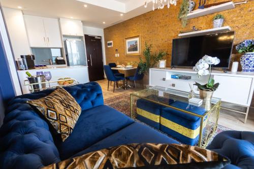 a living room with a blue couch and a tv at Beachfront Suite Ocean-View Balcony 300Mb Fibre in Durban