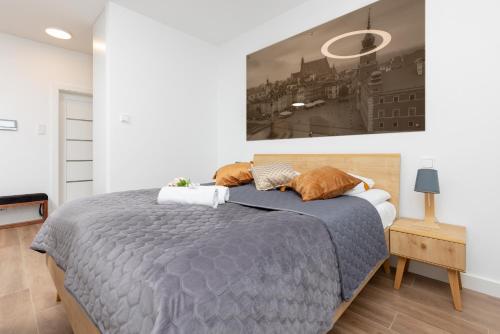 1 dormitorio con 1 cama y una pintura en la pared en Śródmieście Warsaw Muranów Apartments with Parking by Renters, en Varsovia