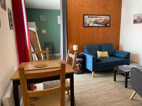 un salon avec un canapé bleu et une table dans l'établissement Le studio dolois, à Dol-de-Bretagne