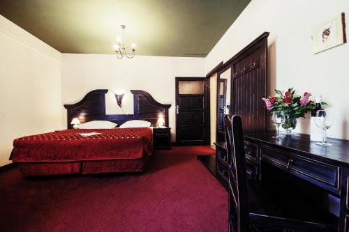 sypialnia z łóżkiem, komodą i stołem w obiekcie Hotel Kasztel w mieście Rzezawa