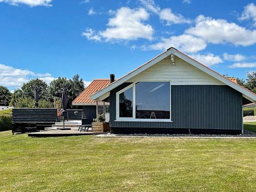 a house with a large window in a yard at 7 person holiday home in Sydals in Sarup