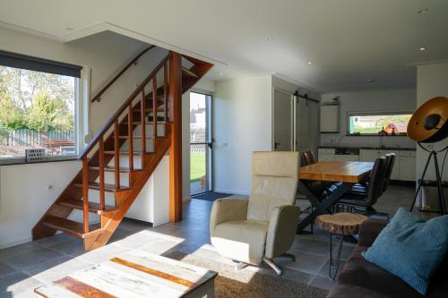 uma sala de estar com uma escada e uma mesa em Prachtig royaal gastenverblijf em Schijndel