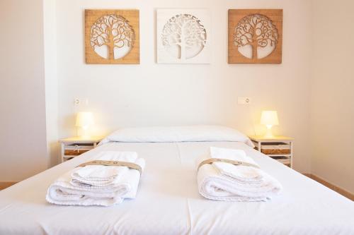 - une chambre avec un lit et des serviettes dans l'établissement Global Properties, Apartamento con gran terraza y piscina, à Canet d'En Berenguer