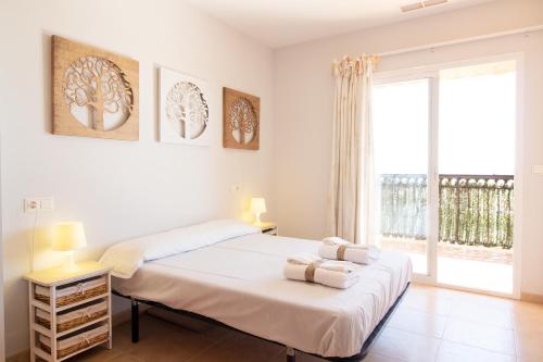 - une chambre blanche avec un lit et une grande fenêtre dans l'établissement Global Properties, Apartamento con gran terraza y piscina, à Canet d'En Berenguer