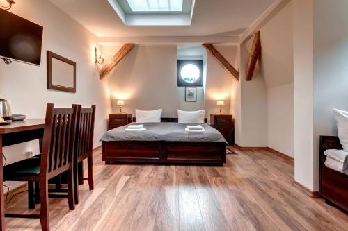 ein Schlafzimmer mit einem Bett und einem Schreibtisch in einem Zimmer in der Unterkunft Hotel Charlotta in Jedlina-Zdrój