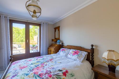 a bedroom with a bed with a floral bedspread at Domaine du Prieuré in Rovagny