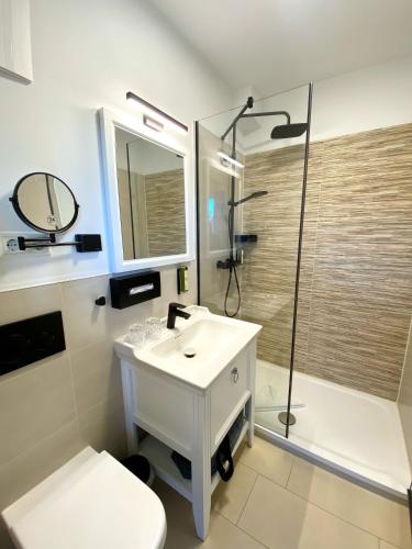 a bathroom with a sink and a shower and a toilet at NP Hotel Wittenbeck in Kühlungsborn
