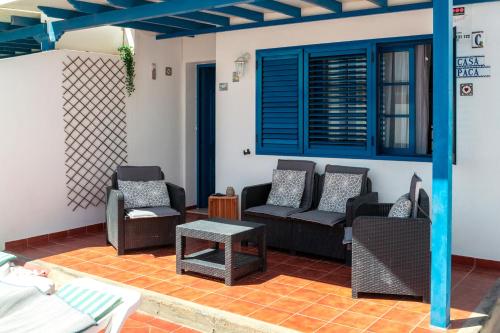 un salon avec des canapés, des chaises et une table dans l'établissement Casa Paca - Your Private Oasis in Lanzarote - Paradise by the Sea, à Playa Blanca