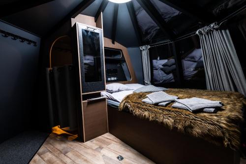 a room with a bed in a tent with a mirror at Aurora hut igloo in Rovaniemi