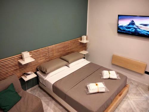 een slaapkamer met een bed en een tv aan de muur bij IlGirasoleApartment in Napels