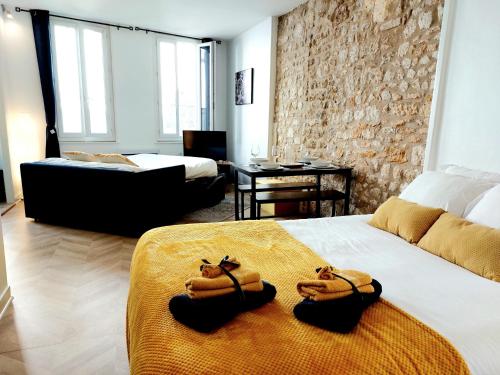 une chambre d'hôtel avec deux lits avec des serviettes dessus dans l'établissement Chaleureux Studio dans le centre historique WIFI, à Angoulême