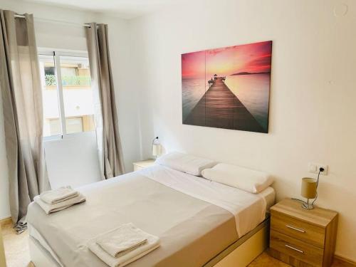 een slaapkamer met een bed met een foto aan de muur bij charming apartment in Torrevieja
