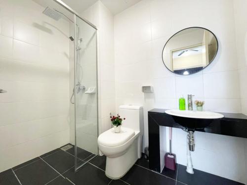 a bathroom with a toilet and a sink and a mirror at Encorp Strand Lovely 2BR Condo at Kota Damansara in Petaling Jaya