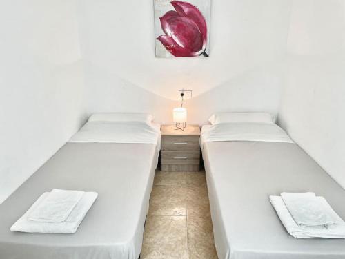 twee bedden in een kleine kamer met een nachtkastje bij charming apartment in Torrevieja