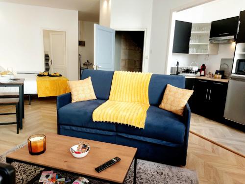 un salon avec un canapé bleu et une cuisine dans l'établissement Chaleureux Studio dans le centre historique WIFI, à Angoulême