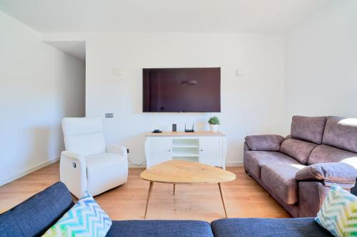 a living room with a couch and a table at PENTHOUSE NEAR BEACH AND MALAGA TOWN also monthly hire and long term RENTAL CAR AVAILABLE in Málaga