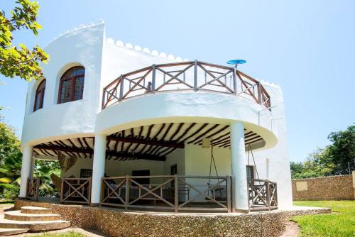 a house with a metal roof and a balcony at Villa PundaMilia Private Pool free wifi secure in Kwale