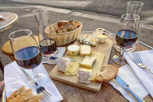 une table recouverte de verres de vin et de fromage dans l'établissement L'ANNEXE Small House with Garden Between - Proche ParisDisney, à Noisy-le-Grand