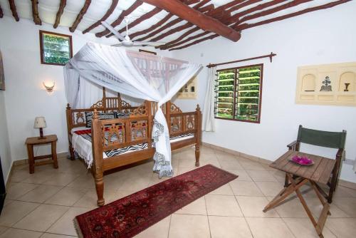 a bedroom with a bed and a table and a chair at Villa PundaMilia Private Pool free wifi secure in Kwale