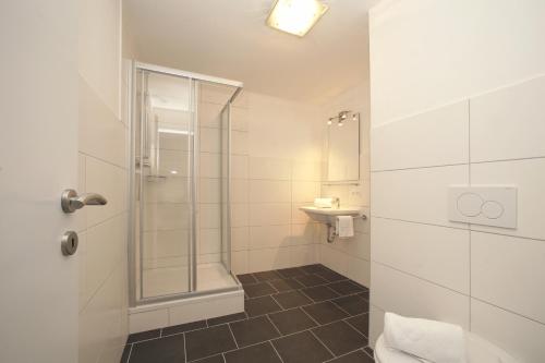 a bathroom with a shower and a toilet and a sink at Lake and Cityhotel Edelweiss - self Check in in Zell am See