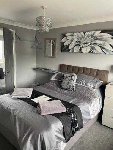 1 dormitorio con 1 cama grande con un cuadro de flores en la pared en No1 Guest House en Stamford