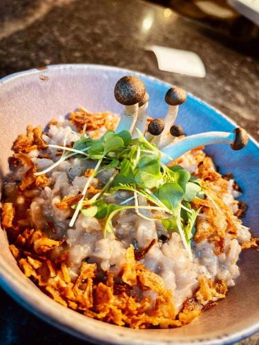 a bowl of food with mushrooms and greens on it at PATE'O Hostel & Suites in Ovar
