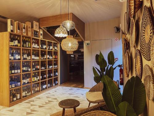 a wine tasting room with shelves of wine bottles at PATE'O Hostel & Suites in Ovar