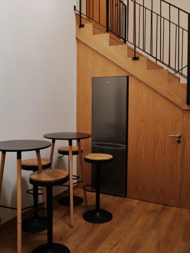 a room with two tables and a tv and stairs at PATE'O Hostel & Suites in Ovar
