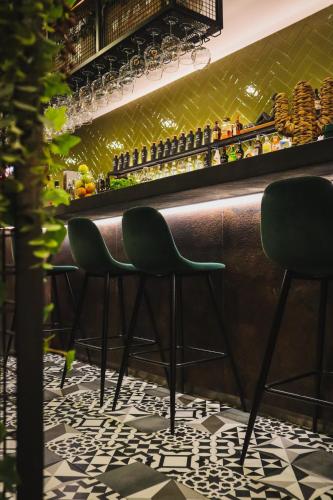 a bar with two green chairs sitting at a counter at PATE'O Hostel & Suites in Ovar