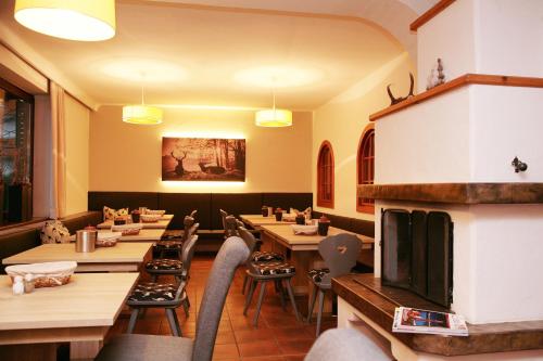 ツェル・アム・ゼーにあるLake and Cityhotel Edelweiss - self Check inの木製のテーブルと椅子、暖炉のあるレストラン