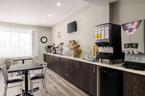a kitchen with a bar with a counter and chairs at Super 8 by Wyndham Sarnia ON in Sarnia