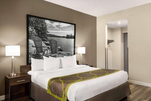 Habitación de hotel con 1 cama grande y 2 lámparas en Super 8 by Wyndham Sarnia ON, en Sarnia