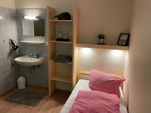 mała łazienka z łóżkiem i umywalką w obiekcie Talstation Heumöderntal w mieście Treuchtlingen